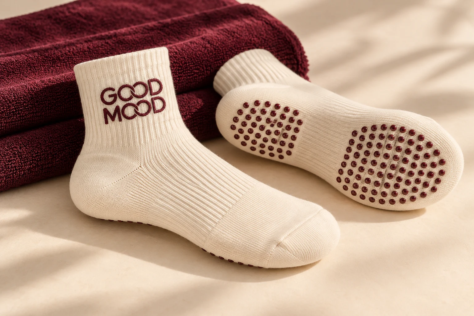 Maquette de chaussettes antidérapantes crème GOOD MOOD, logo bordeaux et picots sous la semelle